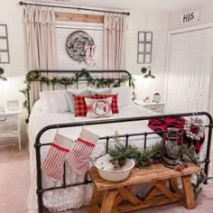 a bedroom decorated for christmas with stockings on the bed and decorations hanging from the ceiling