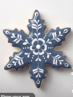 a blue and white ceramic snowflake ornament on a white background with the words show your app