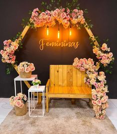 a wooden bench sitting under a neon sign with pink flowers on it's sides