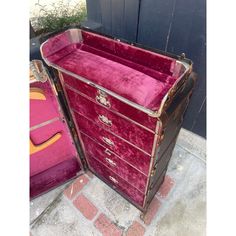 a pink velvet chest sitting on top of a sidewalk