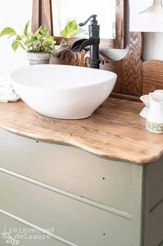 a white bowl sink sitting on top of a wooden counter