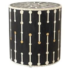 a black and white drum with gold dots on it's sides, sitting in front of a white background