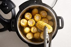 corn on the cob being cooked in an electric pressure cooker