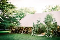 a large tent set up with flowers and greenery