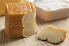 a piece of cheese sitting on top of a wooden table