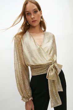 Illuminate the dancefloor in this metallic wrap top. A draped wrap design, this printed blouse will match the disco ball with its mesmerising finish. Shaped with a V-neckline and secured with a waist tie for a fit-and-flare silhouette, it has long sleeves and gathered cuffs. Add oversized hoops and pleated flares for some disco drama.Style: BlouseDesign: MetallicFabric: Fancy FabricLength: RegularNeckline: WrapSleeve Length: Long Sleeve Luxury Evening Blouse, Bright Blazer, Formal Top, Evening Gala, Evening Blouses, Formal Tops, Evening Tops, Evening Wedding, Dress For Success