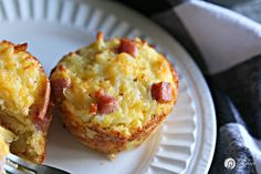 two breakfast muffins on a paper plate with a fork