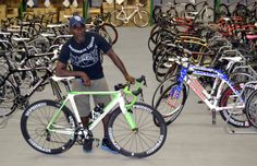 a man standing next to a bunch of bikes