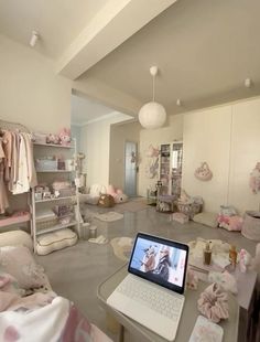 a laptop computer sitting on top of a table in a room filled with baby items