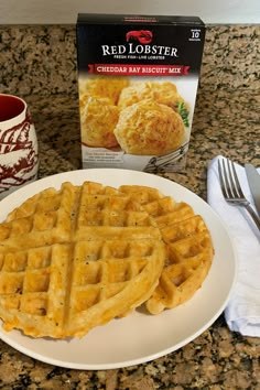 two waffles on a white plate next to a box of red lobster cheddar bay biscuit mix