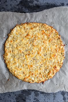 an uncooked pizza sitting on top of a piece of wax paper