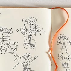 an open book with drawings on it and orange string attached to the page, which has been drawn by someone