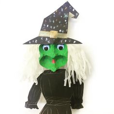 a paper doll wearing a witches hat and black dress