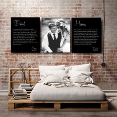 two black and white pictures hanging on the wall above a bed in a room with brick walls