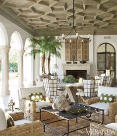 a living room filled with furniture and a fire place in the middle of an open floor plan