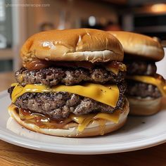 two cheeseburgers sitting on top of a white plate