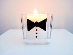 a candle with a black bow tie on it