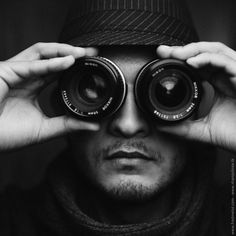 a man is looking through two binoculars