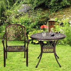 an outdoor table and chair set in the grass with flowers on it's side