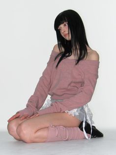 a woman sitting on the floor with her legs crossed and wearing knee high socks while looking off to the side