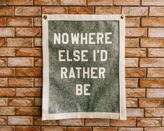 a sign on a brick wall that says nowhere else'd rather be