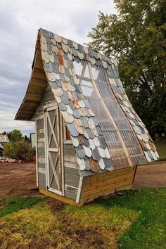 an old shed with a roof made out of corrugated foil and windows on the side