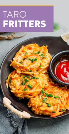 a black plate topped with potato fritters next to ketchup and garlic