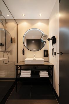 a bathroom with a sink, mirror and shower stall in it's own area