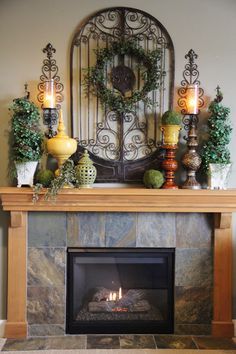 a fireplace in a living room filled with furniture and candles on top of the mantle