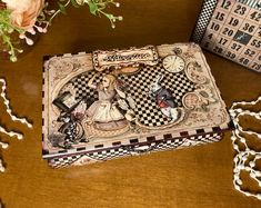 a wooden box sitting on top of a table next to some flowers and a clock