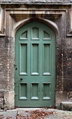 a green door with two windows on an old building