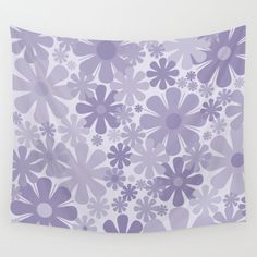 a purple and white wall hanging with flowers on it