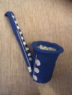 a blue vase sitting on top of a carpet next to a metal spoon and toothbrush holder