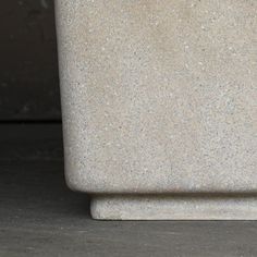 a white vase sitting on top of a cement floor