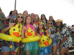 a group of young women standing next to each other in front of a crowd wearing leis