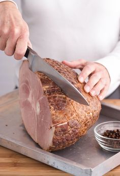 a person cutting meat with a large knife