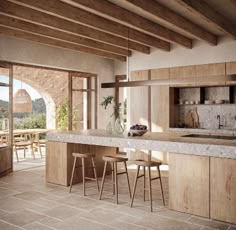 an open kitchen and dining area with stone flooring