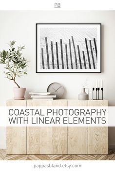 a white room with wooden cabinets and a painting on the wall that says coastal photography with linear elements