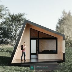 a woman standing in the doorway of a tiny house on stilts with grass and trees behind her