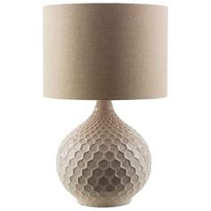 a white table lamp with a beige shade on the base and a round light fixture