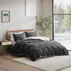 a bed sitting in a bedroom next to a window with a plant on top of it