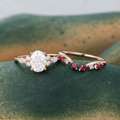 two engagement rings on top of each other with ruby and white diamonds in the middle