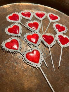 heart shaped cake toppers are on a metal platter with toothpicks in the shape of hearts