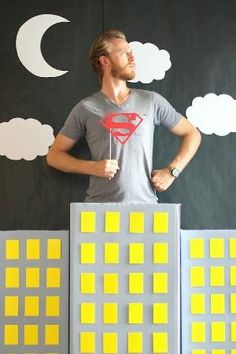 a man standing on top of a building made out of lego blocks with a superman t - shirt