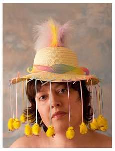 a woman wearing a straw hat with yellow pom poms hanging from it's sides