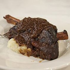 a white plate topped with meat and mashed potatoes