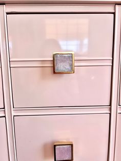 a pink dresser with gold handles and knobs