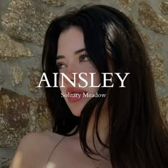 an image of a woman with long hair and no bra posing in front of a stone wall