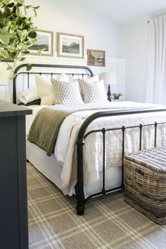 a bedroom with a bed, basket and pictures on the wall