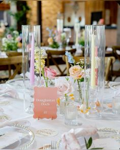 the table is set with flowers and candles